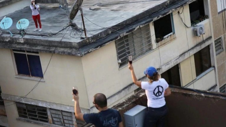 People in Venezuela pass wine across rooftops to celebrate happy hour in quarantine